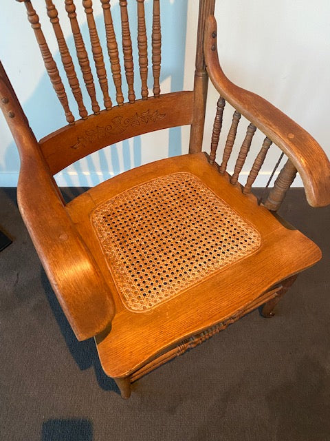 A stunning antique carved cane and oak chair on porcelain castors