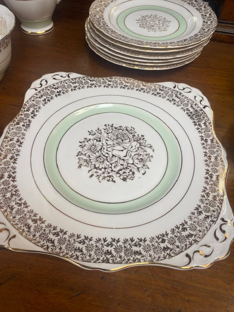 A Tuscan porcelain tea cup and saucer set with matching plates, bowls, and a creamer.