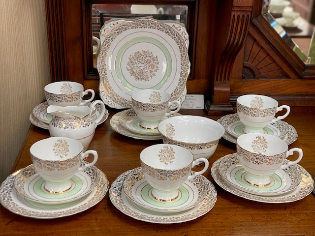A Tuscan porcelain tea cup and saucer set with matching plates, bowls, and a creamer.
