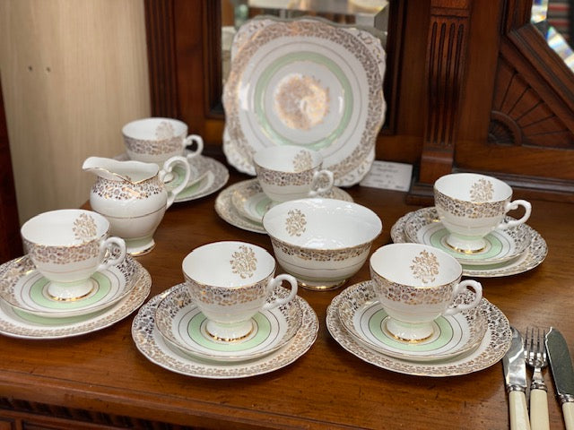 A Tuscan porcelain tea cup and saucer set with matching plates, bowls, and a creamer.