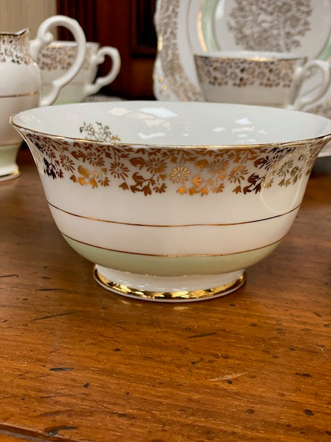 A Tuscan porcelain tea cup and saucer set with matching plates, bowls, and a creamer.
