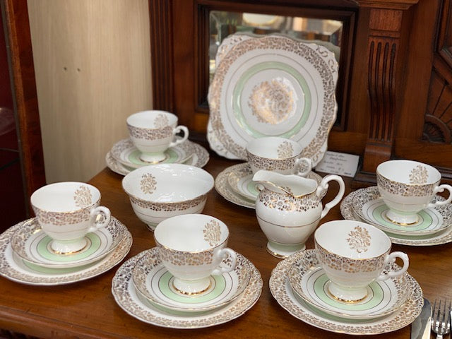 A Tuscan porcelain tea cup and saucer set with matching plates, bowls, and a creamer.