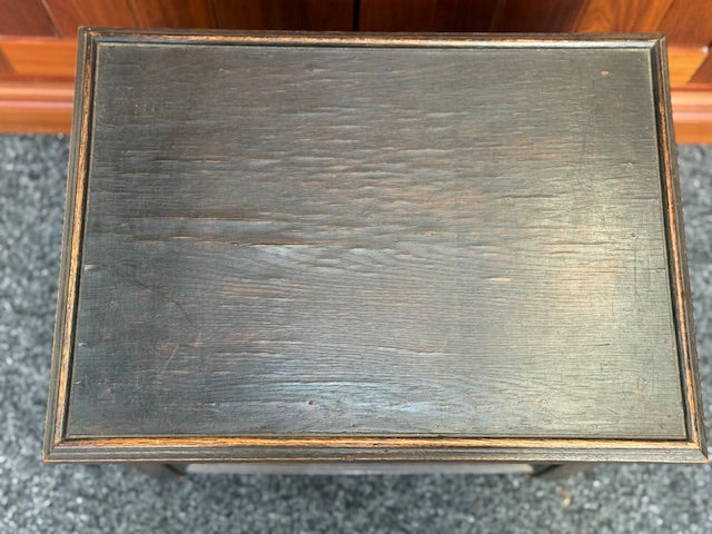 Small Dark stained wooden chest with a hinged lid and a small brass-toned pull handle